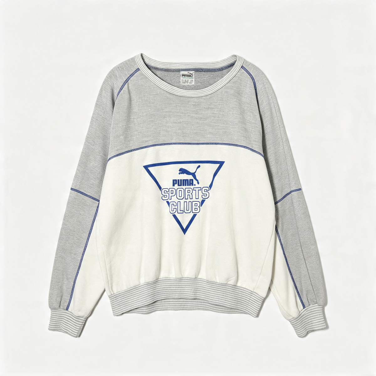 A Puma sweatshirt in heather gray and off-white with blue contrast stitching and a blue 'Puma Sports Club' logo on the front, displayed flat against a light gray background.