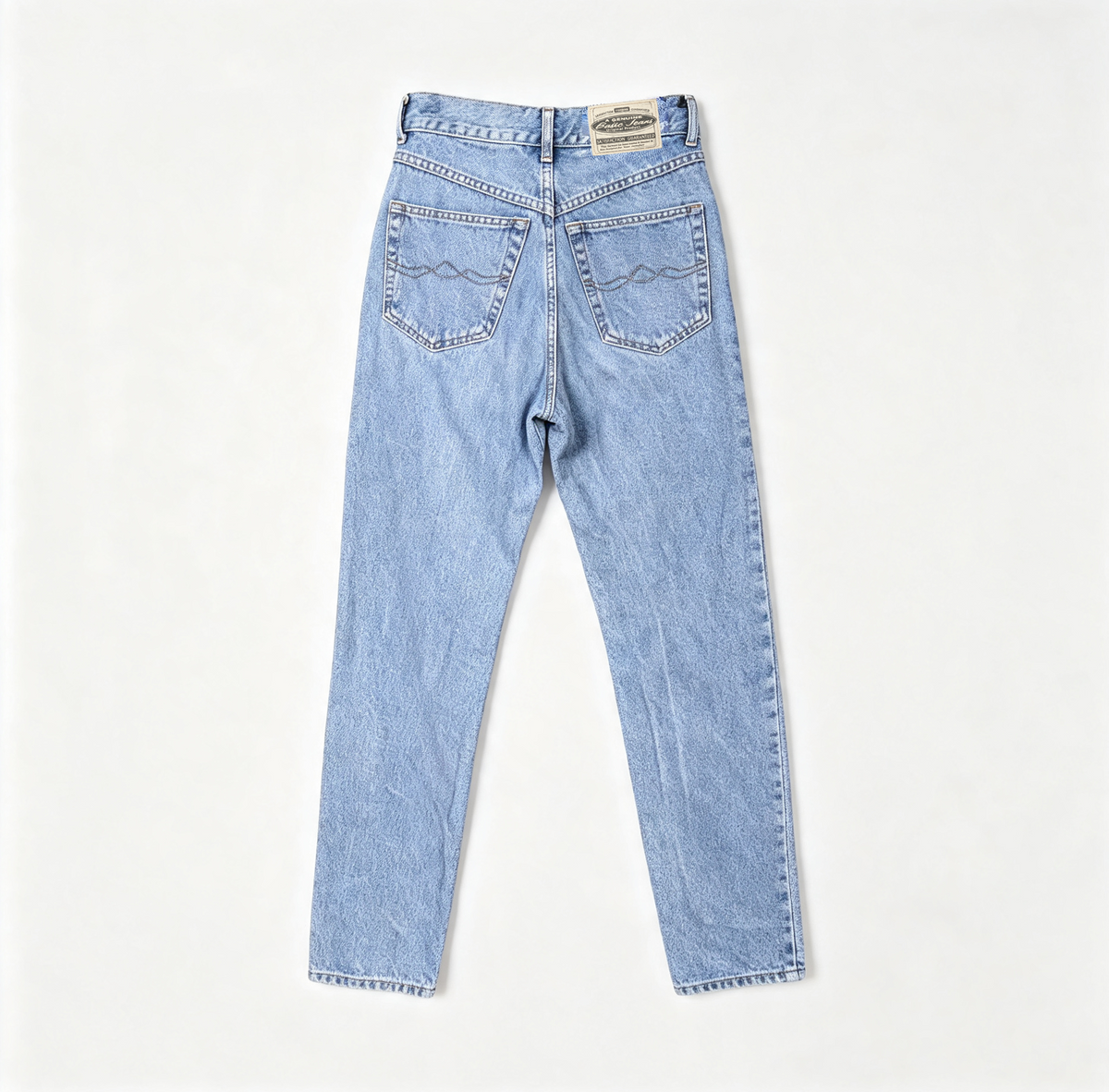 Light wash blue denim jeans shown from the back, featuring a straight-to-slightly-relaxed leg and classic pocket stitching, laid flat on a light off-white background.