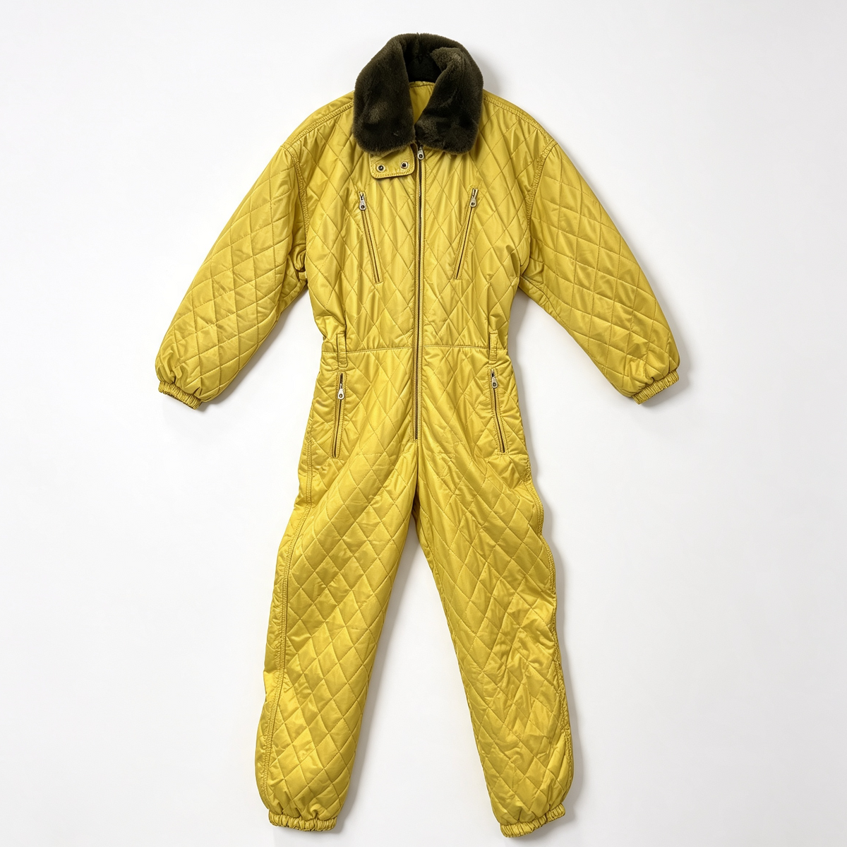A quilted yellow ski jumpsuit with a dark brown faux-fur collar, laid flat on a light gray background.