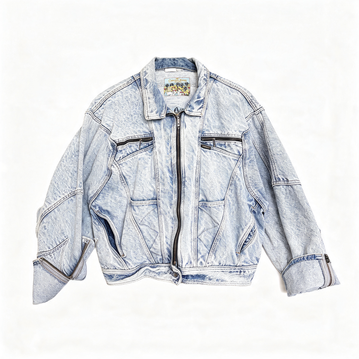 A light blue acid-wash denim jacket with a front zipper, zippered chest pockets, and rolled cuffs, laid flat against a white background.