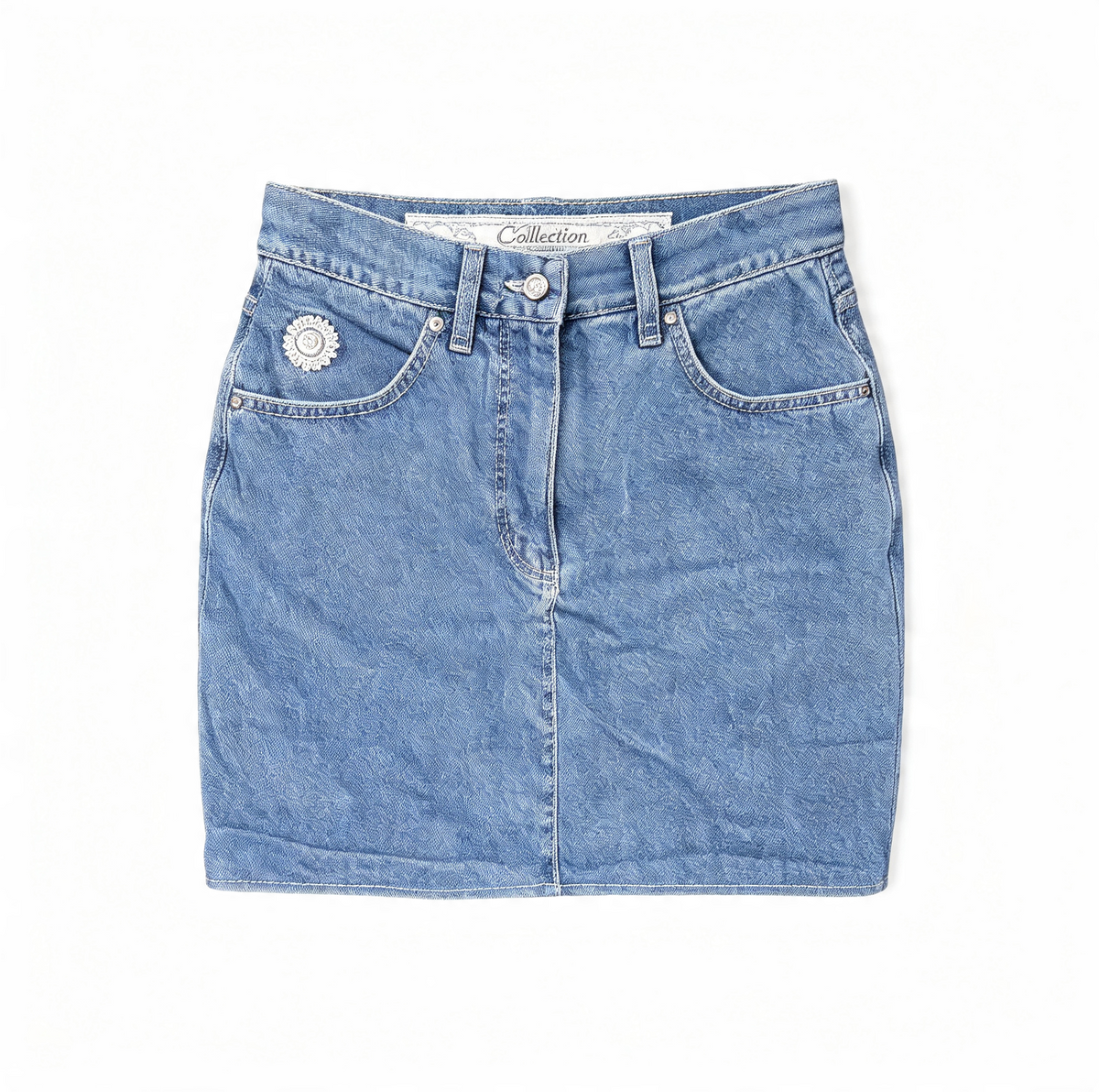 A light blue denim mini skirt with a button fly, belt loops, and a decorative silver-tone flower embellishment on the left pocket, shown flat on a white background.
