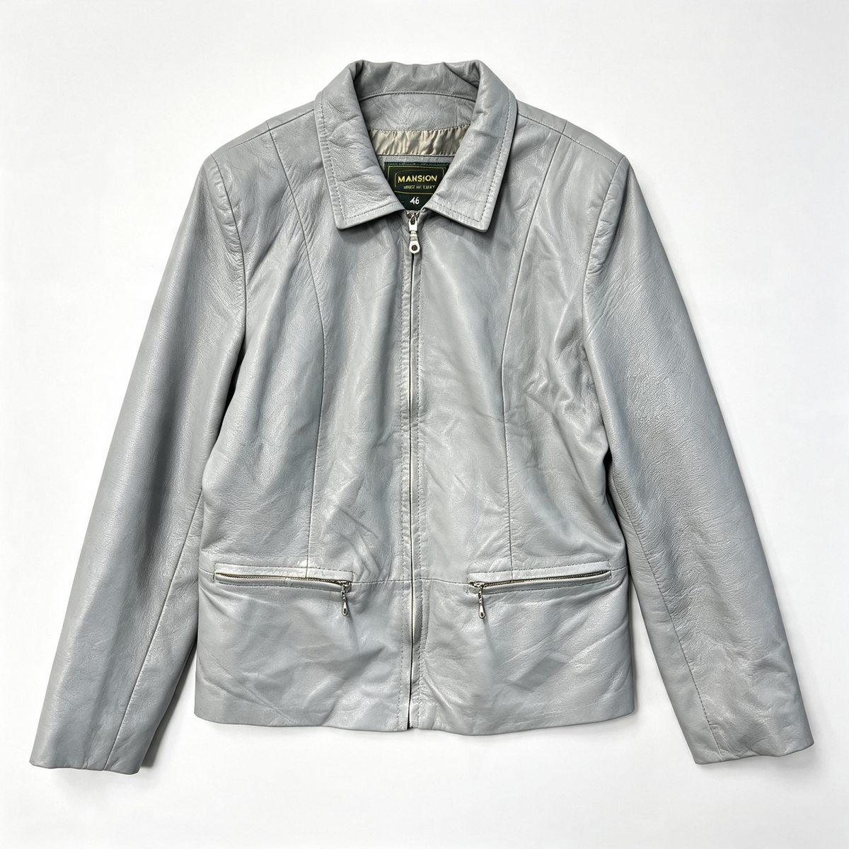 A silver faux-leather jacket with a zippered front, pointed collar, and two zippered hand pockets, laid flat against a white background.