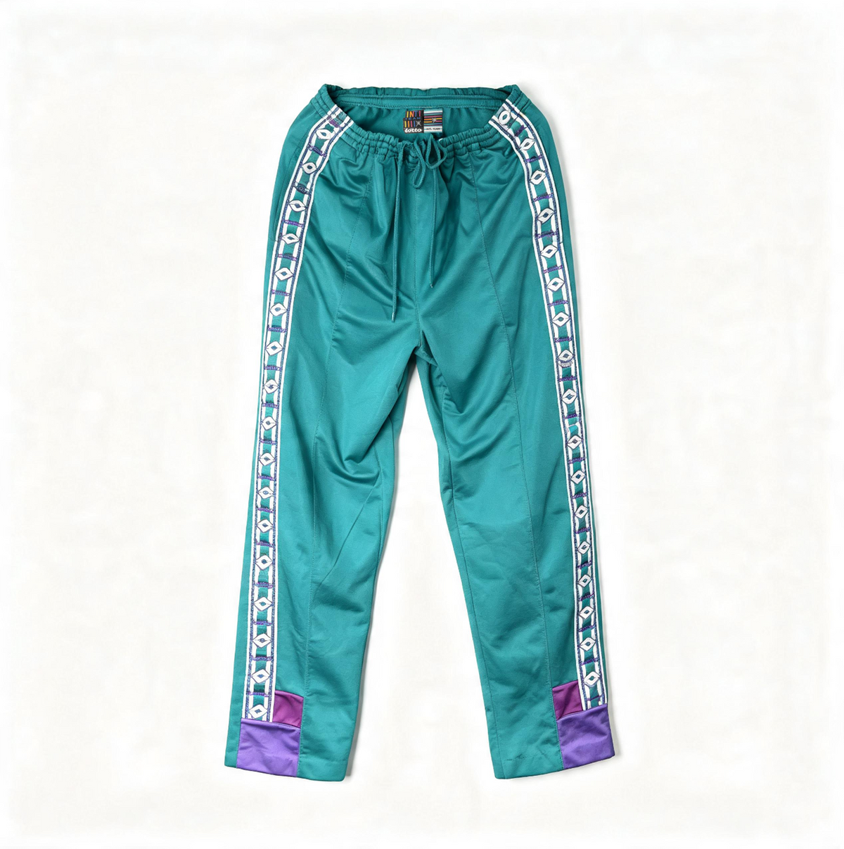 A pair of teal track pants with white and blue patterned side stripes and purple pocket accents at the cuffs, laid flat on a white background.