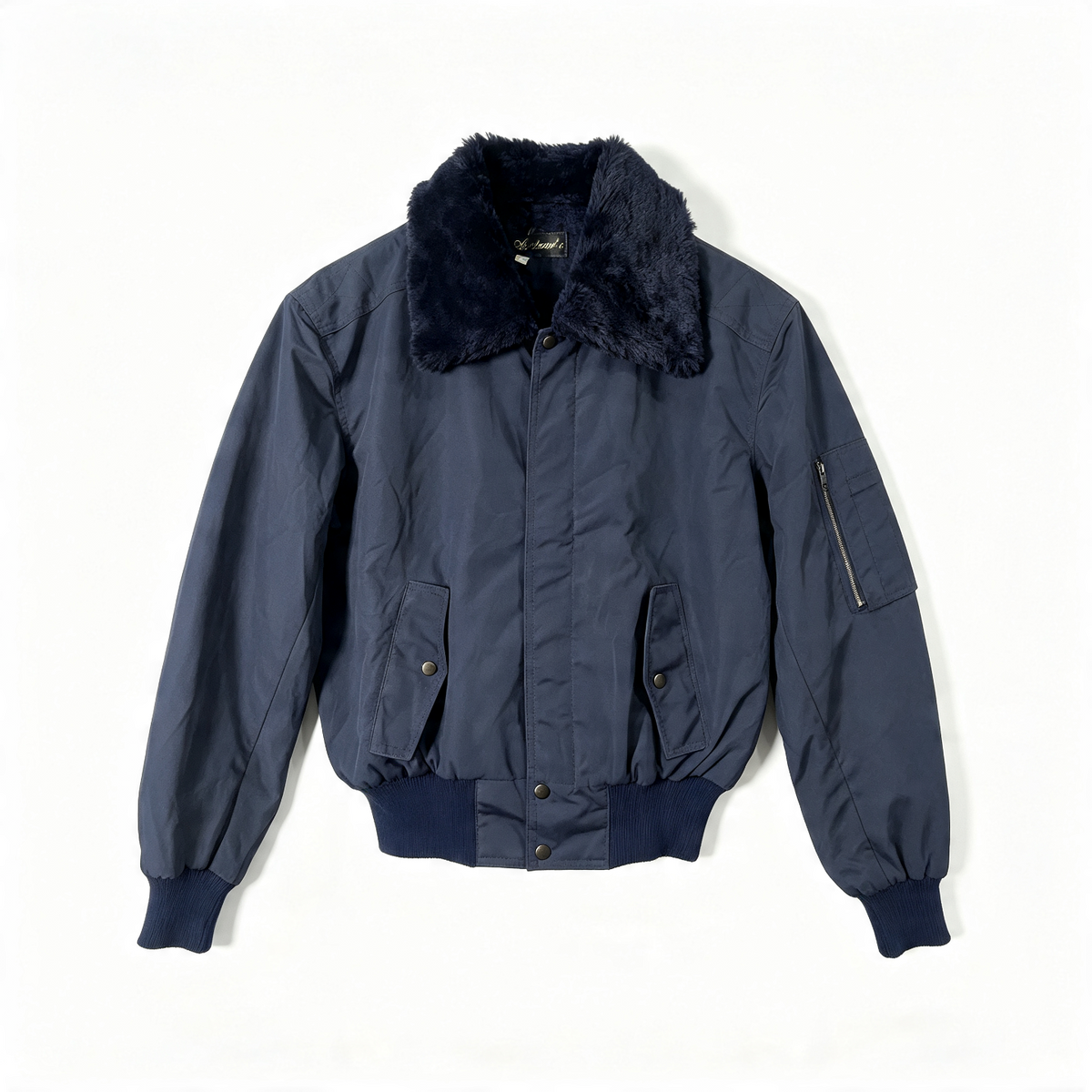 A navy blue quilted bomber jacket with a dark navy faux-fur collar, ribbed knit cuffs and hem, and a zippered sleeve pocket, laid flat against a white background.