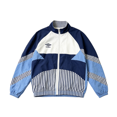 A vintage-style colorblock windbreaker jacket by Umbro, featuring navy blue, light blue, and white panels with striped details, shown flat on a white background.