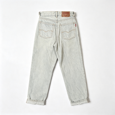Back view of a pair of light-wash denim jeans with rolled cuffs, laid flat on a white background. The brand is visible on the brown leather waistband patch.