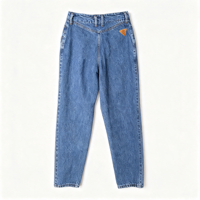 A pair of faded blue denim jeans laid flat against a clean, off-white background. The jeans feature a relaxed, straight-to-slightly-relaxed leg and a small orange embroidered logo on the upper right hip.
