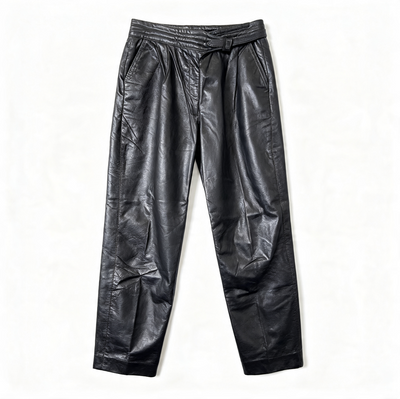 Black leather pants with an elastic waistband and tie belt, laid flat on a white background.