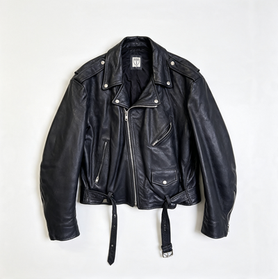 A black leather motorcycle jacket with a zippered front, silver snap details, and a matching black leather tie belt, laid flat against a white background.