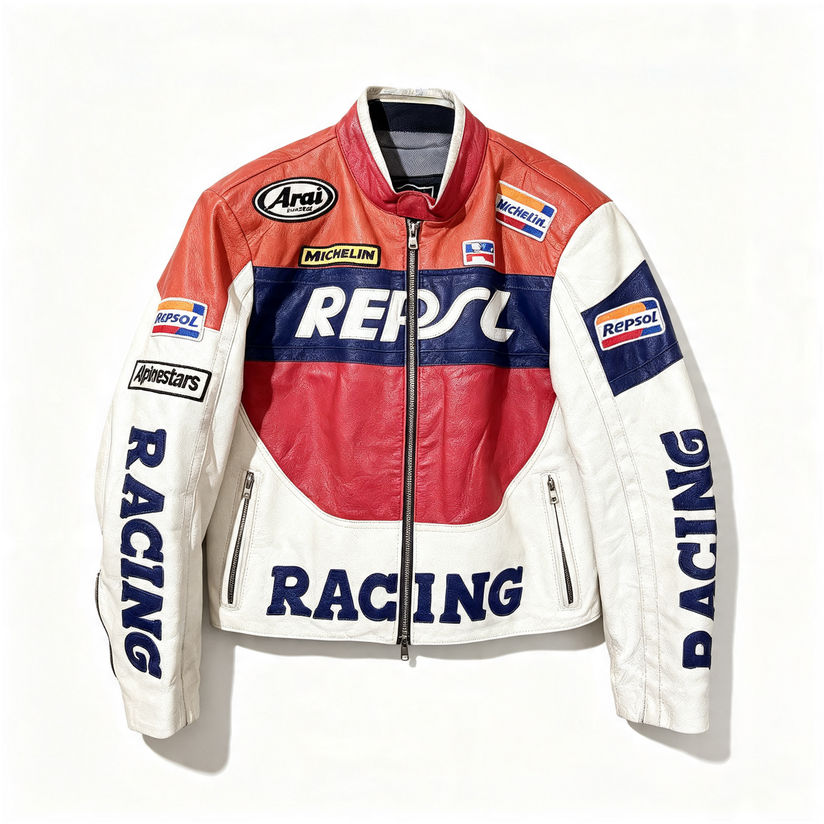 A vintage-style leather racing jacket with red, white, and navy blue panels, featuring prominent 'REPSOL RACING' logos and sponsor patches including 'Arai', 'Michelin', and 'Alpinestars'.