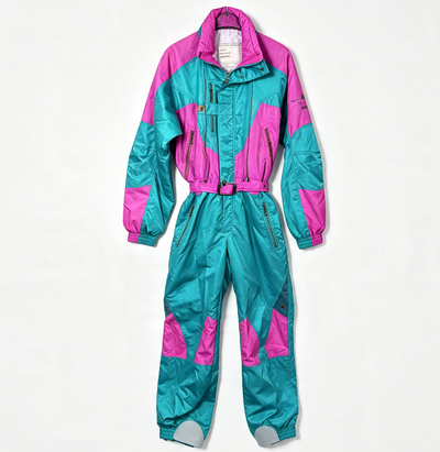 A two-piece shiny snowsuit with a zip-front, featuring bright teal and hot pink color blocking with gray toe covers, laid flat against a white background.