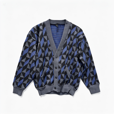 A long-sleeve knit cardigan with a geometric pattern of black, gray, and blue triangles, featuring a gray ribbed V-neck, button closure, and cuffs.