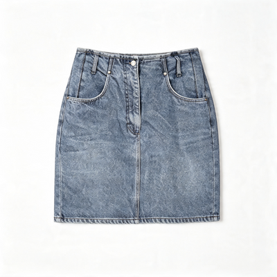 A light blue denim mini skirt with a faded wash, featuring a front button closure, belt loops, and two large front patch pockets, laid flat against a white background.