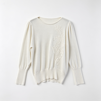 An off-white long-sleeve knit sweater with a delicate floral embroidery on the right chest, displayed flat against a light gray background.