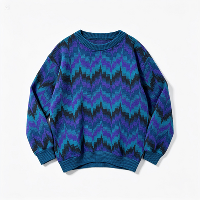 A crewneck knit sweater with a vibrant chevron pattern in shades of blue, purple, and black, displayed flat against a clean white background.
