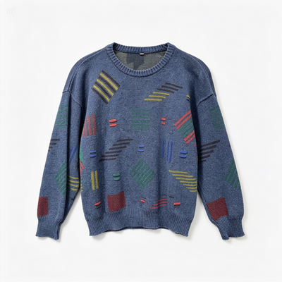 A blue crewneck knit sweater featuring a colorful geometric pattern of stripes, squares, and diamonds woven into the fabric, displayed on a clean white background.