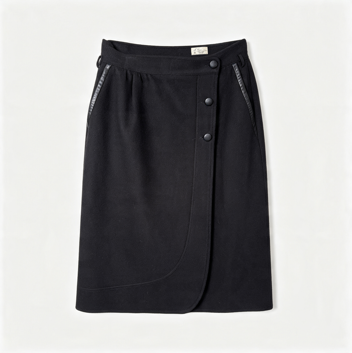 A black wrap-style skirt with an asymmetrical button closure and side pockets, photographed flat against a light gray background.