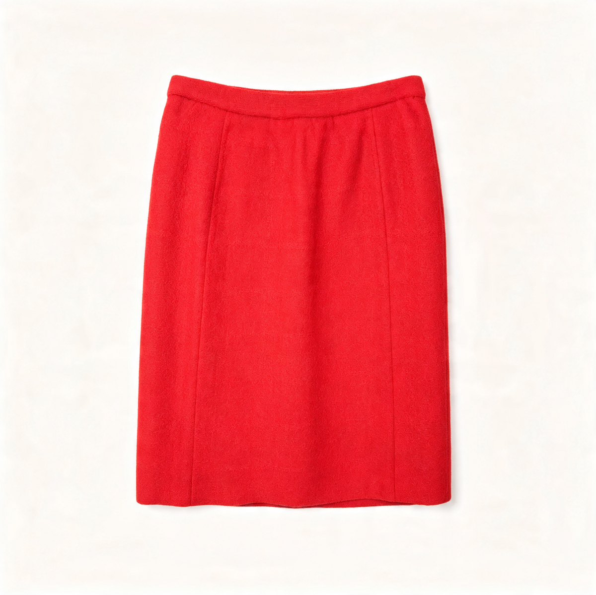 A bright red knee-length wool skirt with a straight, slightly flared silhouette and subtle front seam panels, shown flat against a light off-white background.